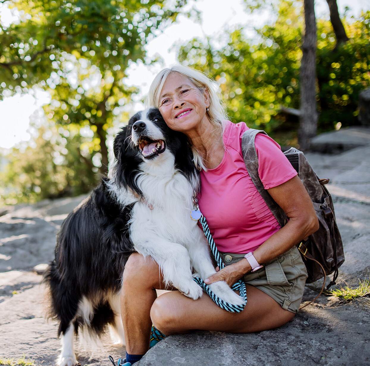 Senior,Woman,Resting,And,Stroking,Her,Dog,During,Walking,In