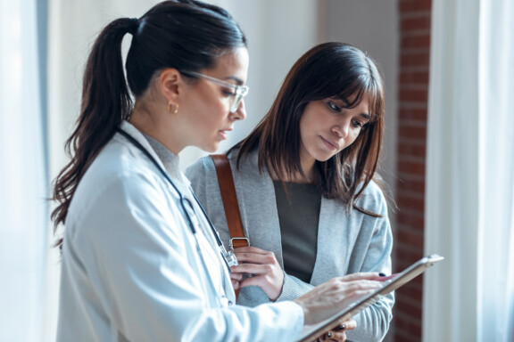 Shot,Of,Beautiful,Female,Doctor,Talking,While,Explaining,Medical,Treatment
